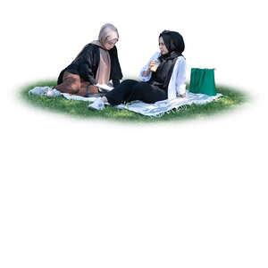 two cut out muslim girls sitting in the park on the grass