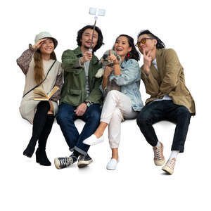 group of four asian friends sitting and taking a selfie