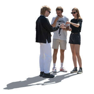 backlit group of three people standing and eating