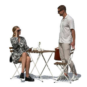 woman sitting in a cafe and talking to a man standing by her