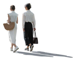 two backlit women walking