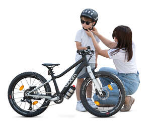 cut out woman putting a helmet on his son with a bike