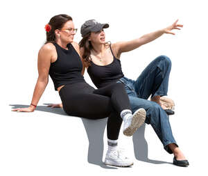 two women sitting outside and looking at smth