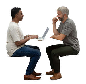 two men sitting face to face and talking