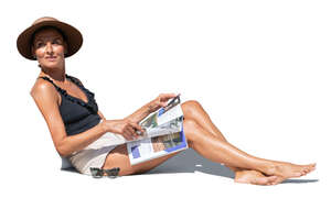 cut out woman lying on a sofa in the sun and reading a magazine 
