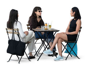 three girlfriends sitting in a cafe and talking
