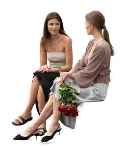 two women at a formal event sitting and talking