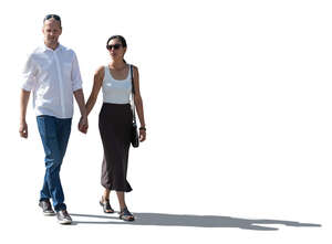 backlit man and woman walking holding hands