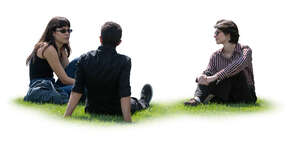 group of friends sitting on a grass and talking