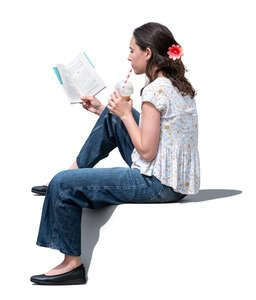 woman sitting and reading and drinking ice latte