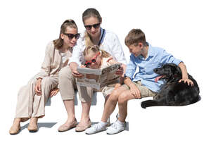 woman with three children and a dog sitting on a sofa and reading