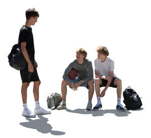 backlit group of teenage boys sitting and standing