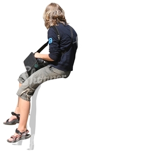 Boy in shorts sitting on a fence