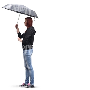 red-haired woman in jeans standing under an umbrella