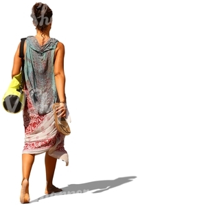 woman walking barefoot and carrying a yoga mat bag and sandals