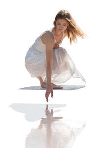 woman in a white dress squatting by the pool