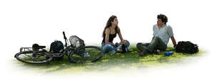 cut out man and woman with bikes sitting on the grass under a tree