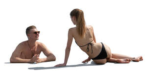 man in the pool talking to a woman sunbathing