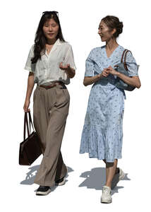 two asian women walking and talking outside