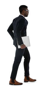 black businessman in a sleek black suit walking