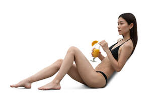 asian woman sunbathing and drinking a cocktail