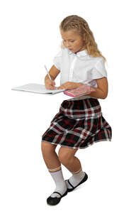 cut out schoolgirl sitting at a desk and writing