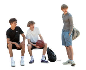 three young boys with a basketball resting after a game