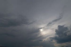 grey sky with sun between the clouds