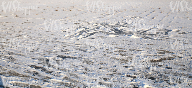 snow-covered ground with messy footprints