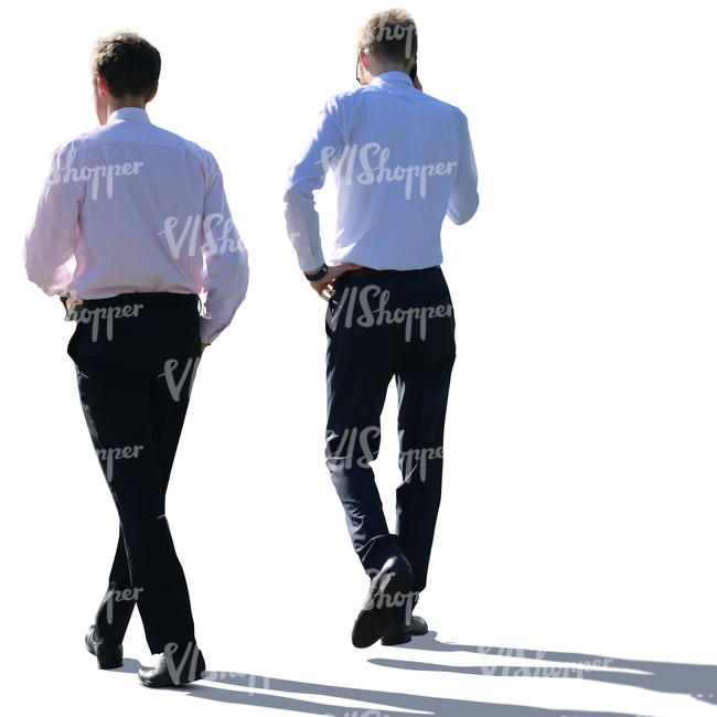 two backlit businessmen walking