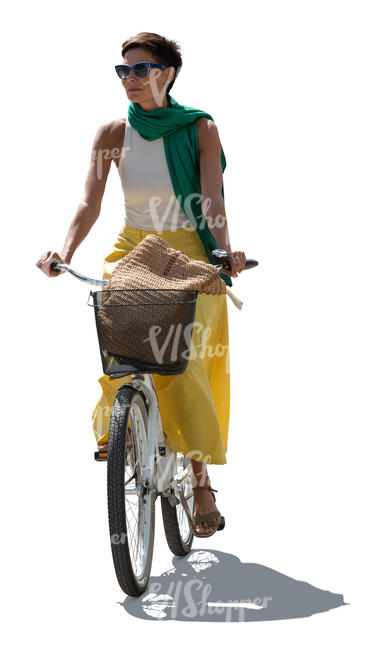backlit woman in a colorful outfit riding a bike