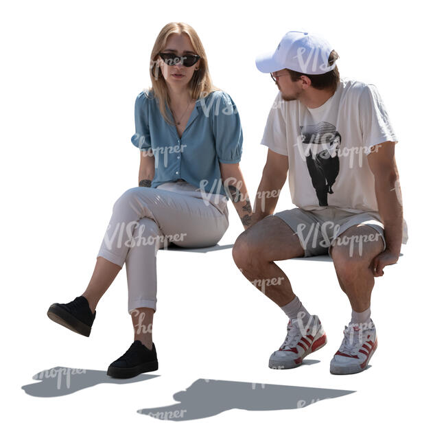 two backlit people sitting and talking