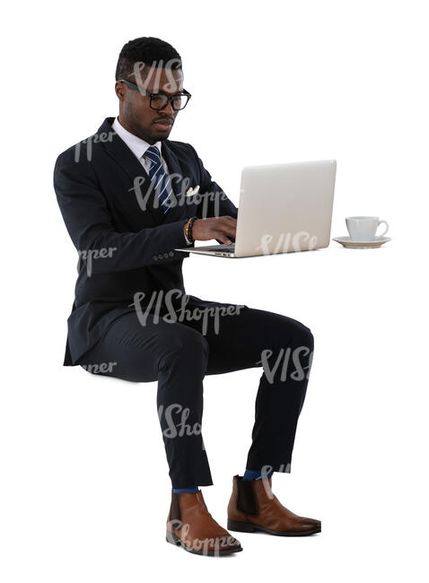 cut out black man sitting and working with computer and drinking coffee