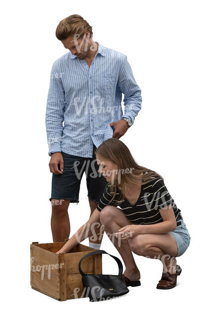 man and woman looking smth from the box on the market