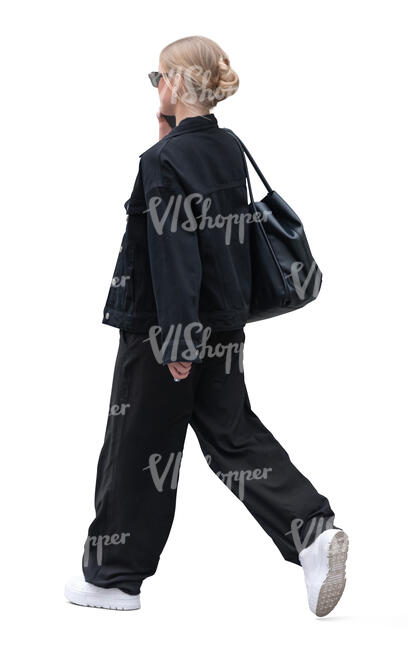 cut out woman in casual black outfit walking and talking on the phone