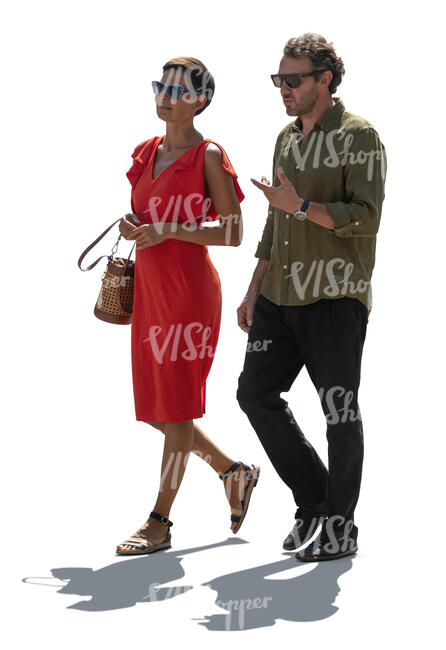 two adult people walking in backlight