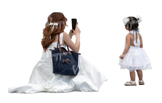 cut out woman in a white dress taking a picture of her little daughter
