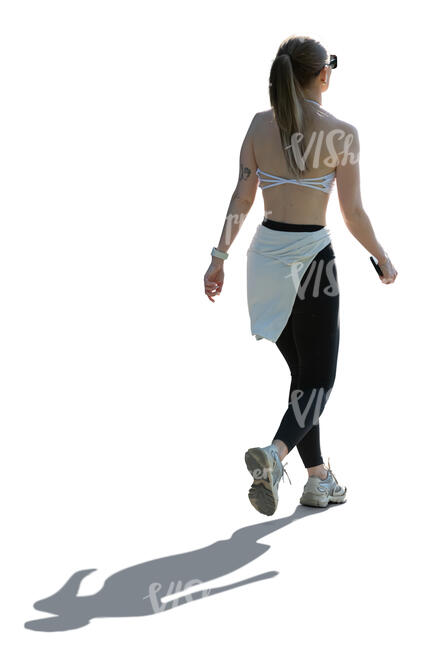 cut out woman in a sporty outfit walking in backlight