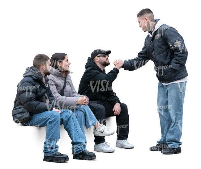 group of friends sitting and greeting a young man