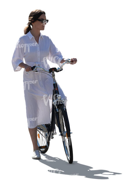 backlit woman in a white dress riding a bike