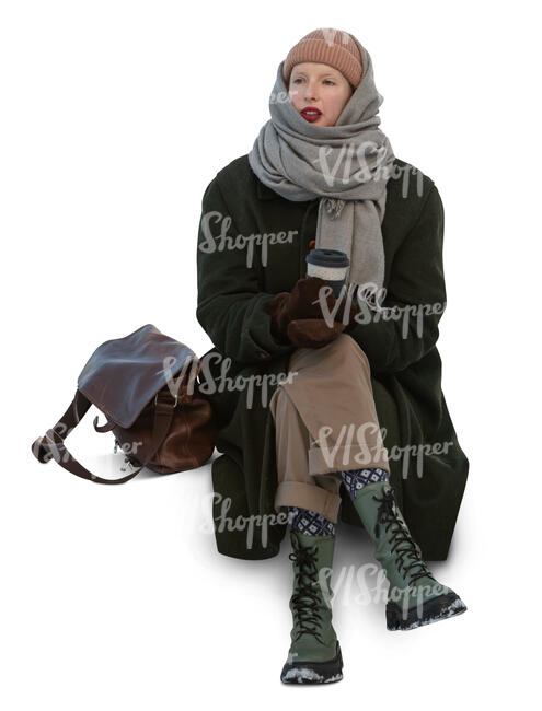 cut out young woman in winter sitting and drinking coffee