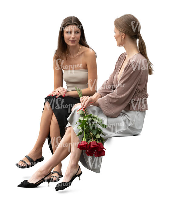 two women at a formal event sitting and talking