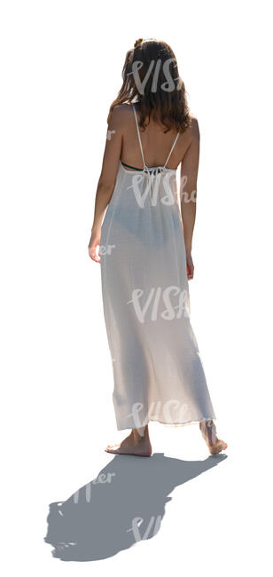 backlit woman in a white dress standing barefoot