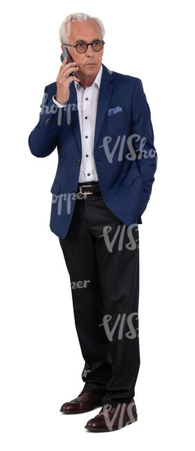 older businessman in a suit standing and talking on a phone