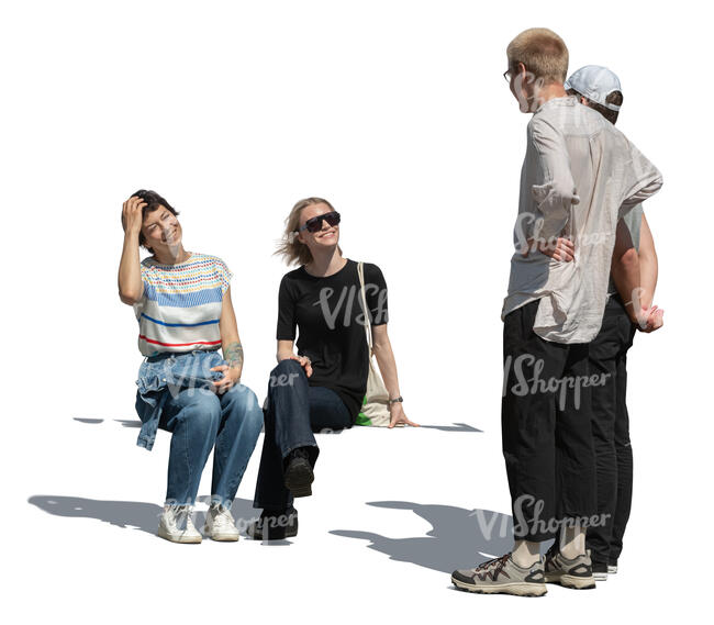 two guys talking to two girls who are sitting