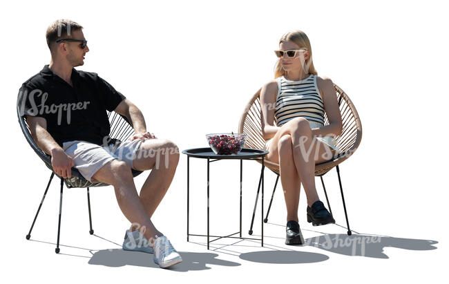 man and woman sitting in armchairs outdoors
