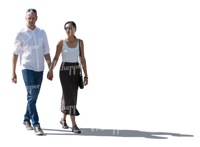 backlit man and woman walking holding hands