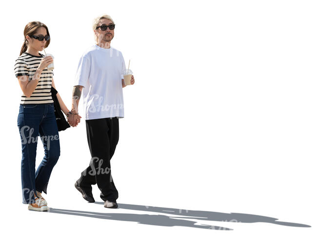 backlit couple with coffee drinks walking hand in hand