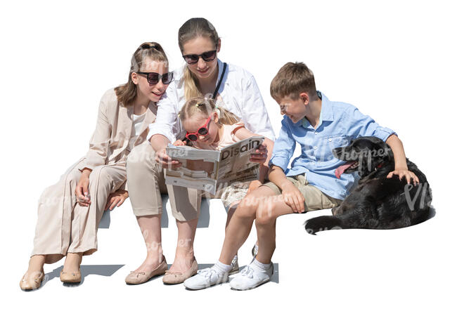 woman with three children and a dog sitting on a sofa and reading
